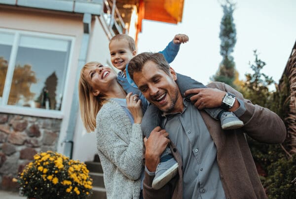 Personal Insurance - Happy Family Outside on a Beautiful Day Holding Their Son on Their Arms With a Smile